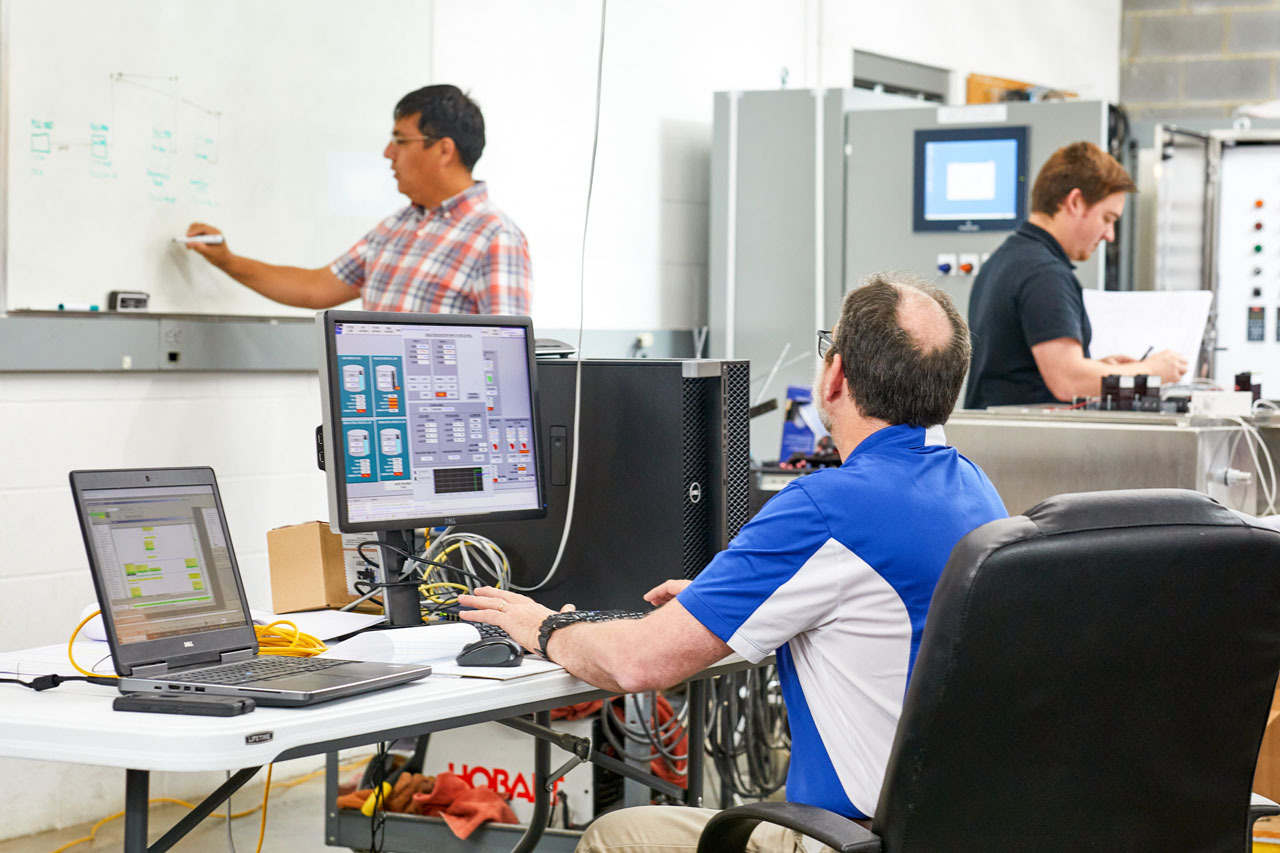 interior photo of three men working at Lord and Company industrial automation shop