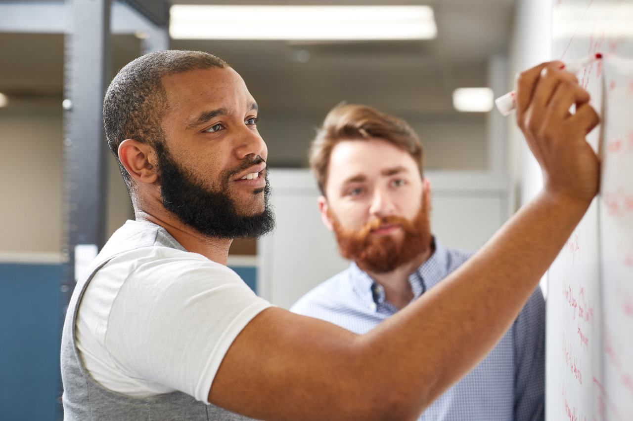 Two men working at a whiteboard