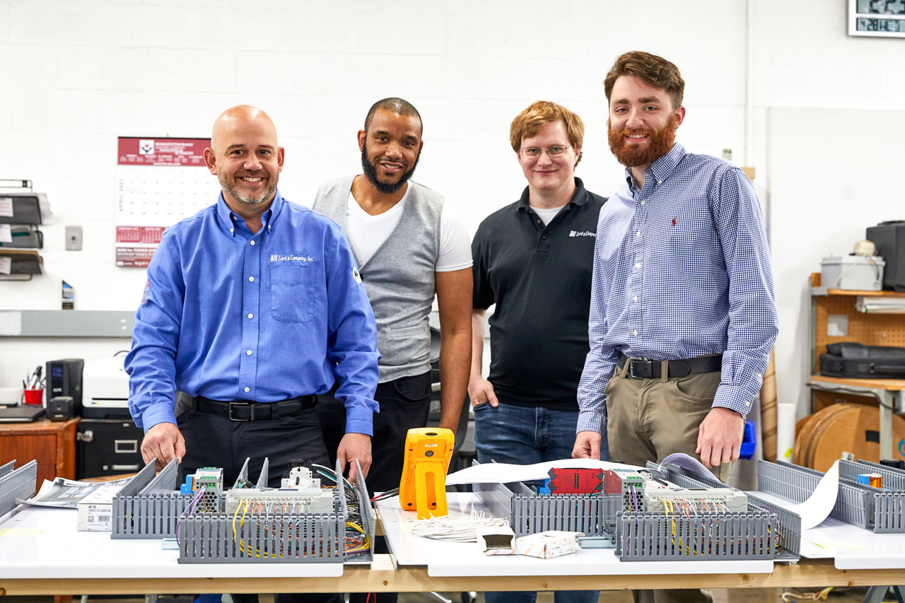 four smiling male employees of Lord & Company Industrial Automation