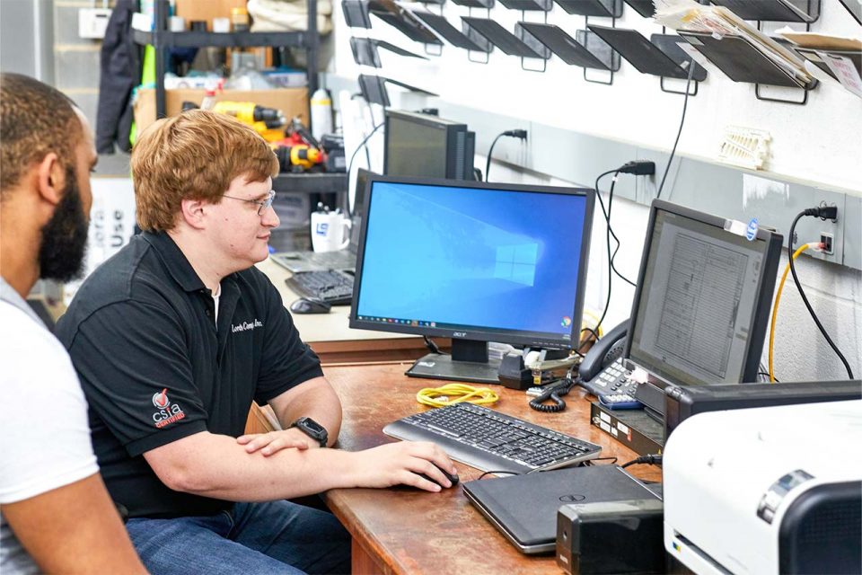 two male employees of Lord & Company Industrial Automation looking at a computer monitor